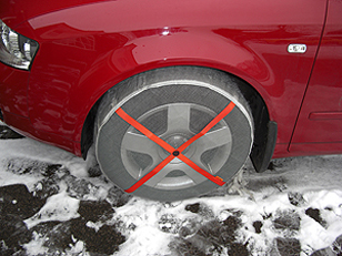 Red car with AutoSock snow socks on