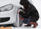 Woman fitting AutoSock snow socks in the snow